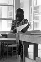 Boy using a saw at the Potomac School as part of the Adams-Morgan Community Council's Potomac Summer Project, McLean, Virginia