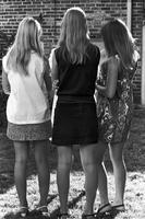 Backs of three young women wearing skirts