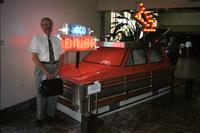 Man posing in front of "goodeats" car at Yugo Next exhibition in Union Station, Washington, D.C.