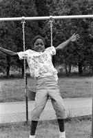 Child jumping from a swing at the Potomac School as part of the Adams-Morgan Community Council's Potomac Summer Project, McLean, Virginia