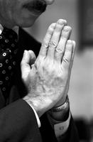 Close-up of hands of man praying in church