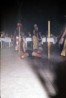 Person performs the limbo with dancers in the background