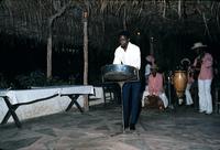 Man playing steel drum in front of a three piece band
