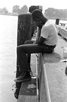 Adolescent male sitting on dock fishing