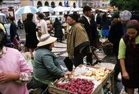 Vendor selling vegetables while people are looking on 