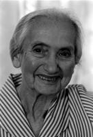 Alternate view of a smiling elderly woman wearing a striped dress