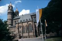 Man standing by a flag pole outside the Cathedral of Saint Peter, Worms, Germany