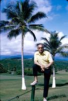 Herb Striner posing in front of vista with palm trees
